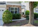 A welcoming entrance featuring attractive stone accents, a covered porch, and lush landscaping creating great curb appeal at 238 Royal Tower Way, Cary, NC 27513