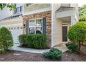 Charming front entrance with a stone facade, lush shrubbery, and a pathway leading to the front door at 238 Royal Tower Way, Cary, NC 27513