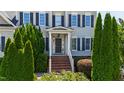 Charming front entrance with brick steps and lush landscaping showcasing curb appeal at 307 Beacon Falls Ct, Cary, NC 27519