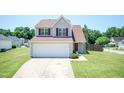 Charming two-story home featuring neutral siding, a well-manicured lawn, and an attached two car garage at 4125 Scofield Dr, Raleigh, NC 27610