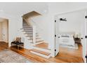 Inviting entryway with hardwood floors, staircase, and a glimpse into a light-filled bedroom at 415 E Lavender Ave, Durham, NC 27704