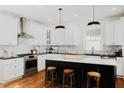 Modern kitchen featuring white cabinetry, black island, marble backsplash, and stainless steel appliances at 415 E Lavender Ave, Durham, NC 27704