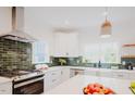 Bright kitchen with green tile backsplash, stainless steel appliances, and ample natural light at 415 E Lavender Ave, Durham, NC 27704