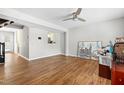 Bright living room featuring hardwood floors, a ceiling fan, and an open view to the kitchen at 4649 Pine Trace Dr, Raleigh, NC 27613