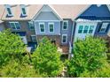 Exterior view of a townhome with stone and siding, well-manicured trees, and a covered entryway at 4963 Highcroft Dr, Cary, NC 27519