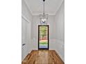 Stylish foyer featuring hardwood floors, wainscoting, and a unique modern light fixture at 503 Damascus Church Rd, Chapel Hill, NC 27516