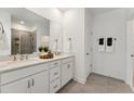 Bathroom featuring double sinks, white cabinets, and a tiled shower at 509 Kildaire Farm Rd # 101, Cary, NC 27511