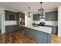 Modern kitchen featuring gray cabinets, quartz countertops, stainless steel appliances, and a large island with pendant lighting at 5545 Silk Hope Gum Springs Rd, Siler City, NC 27344