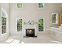 Bright living room with a fireplace and large windows providing an abundance of natural light at 5940 Dahlberg Dr, Raleigh, NC 27603