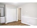 Hallway with wood-look flooring, wainscoting, and closet with bi-fold doors at 621 Reservoir St, Durham, NC 27703