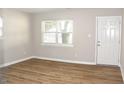 Bright living room with wood-look flooring and a white front door at 621 Reservoir St, Durham, NC 27703