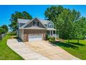 Spacious house with a three car garage, long driveway, and a well-manicured lawn at 63 Majestic Oak Dr, Garner, NC 27529