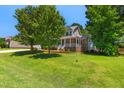 Beautiful residence featuring mature trees and a welcoming front porch, offering a tranquil curb appeal at 63 Majestic Oak Dr, Garner, NC 27529