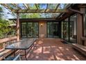 Spacious brick back patio with pergola, glass table, and sliding glass door entrance at 6700 Falconbridge Rd, Chapel Hill, NC 27517