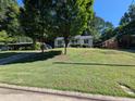 A charming home sits on a lush green lawn beneath mature trees at 908 E Hudson Ave, Durham, NC 27704