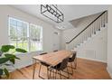 Bright dining room features wood floors, modern light fixture, and large window overlooking the front yard at 9508 Waterwood Ct, Raleigh, NC 27614