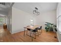 Another view of dining room with wood floors, modern light fixture, and plant at 9508 Waterwood Ct, Raleigh, NC 27614