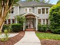 Beautiful two-story home featuring a covered front porch, gray siding, lush landscaping, and a welcoming entrance at 105 Jolyn Pl, Chapel Hill, NC 27517