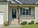 Close-up of front porch and door with storm door and stone detail at 115 Snowy Orchid Ln, Smithfield, NC 27577