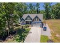 Aerial view of a two-story home with a long driveway and a well-landscaped front yard at 1176 Sagamore Dr, Louisburg, NC 27549