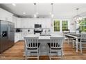 Bright kitchen with white cabinets, stainless steel appliances, quartz countertops and a dining area at 1176 Sagamore Dr, Louisburg, NC 27549