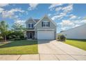 Charming home with light gray siding, black shutters, and a two-car garage with a concrete driveway at 123 Teaser Dr, Fuquay Varina, NC 27526