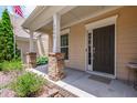 Inviting front porch with brick-based columns and a dark-stained front door at 1320 Cozy Oak Ave, Cary, NC 27519