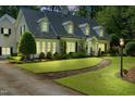 Charming two-story home boasts a lush lawn, beautiful landscaping, and inviting stone walkway at 1610 Ridge Rd, Raleigh, NC 27607