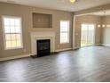 Open living space with fireplace, gray flooring, and sliding glass doors to backyard at 1618 Brownairs Ln, Raleigh, NC 27610
