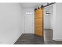 View of the entryway and sliding wood door to a bedroom, showcasing the modern design at 209 S Harrison Place Ln, Fuquay Varina, NC 27526