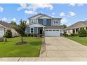 Charming two-story home with a two-car garage, well-manicured lawn, and beautiful landscaping at 209 S Harrison Place Ln, Fuquay Varina, NC 27526