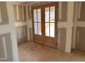 The entryway has wooden french doors leading outside with drywall installed at 240 Noramac Ct, Selma, NC 27576