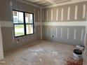 A living room under construction with bare floors and a black window to the outside at 240 Noramac Ct, Selma, NC 27576