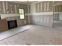 A large living room under construction with a fireplace and a black window to the outside at 240 Noramac Ct, Selma, NC 27576