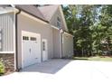 Exterior view showing a one-car garage and side entrance to the home and driveway at 2471 Golden Forest Dr, Franklinton, NC 27525