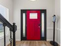 Inviting entryway featuring a striking red front door with sidelights, complemented by wood floors at 274 Marsh Creek Dr, Garner, NC 27529