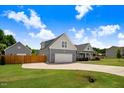 View of the home showing a well-maintained lawn and extended driveway to the garage at 282 Brodie Rose Landing Way, Smithfield, NC 27577
