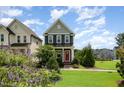 Inviting two-story home boasts a well-manicured lawn, colorful front garden, and charming entry at 283 Daniel Ridge Rd, Wendell, NC 27591