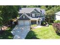 Charming two-story home with a well-manicured lawn, stone accents, and a two-car garage, exuding curb appeal at 308 Wescott Ridge Dr, Holly Springs, NC 27540