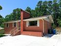 Single-story brick home featuring white trim, a brick chimney, and a freshly painted porch at 3323 Baugh St, Raleigh, NC 27604