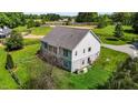 Aerial view of the back of the home with neutral siding, a gray roof, lush green grass, and a partially fenced in yard at 3511 Corbett Rd, Mebane, NC 27302