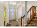 Inviting foyer featuring dark hardwood floors, a staircase, and a doorway leading to the front entrance at 3610 Long Ridge Rd, Durham, NC 27703