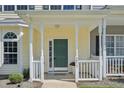 Charming covered front porch with green front door, white railings, and address signage at 3973 Volkswalk Pl, Raleigh, NC 27610