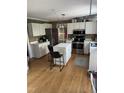 Well-lit kitchen with white cabinetry, stainless steel appliances, and an island with seating at 4117 Mangrove Dr, Raleigh, NC 27616