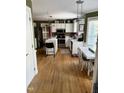 Bright eat-in kitchen featuring hardwood floors, white cabinetry, stainless steel appliances, and a center island at 4117 Mangrove Dr, Raleigh, NC 27616