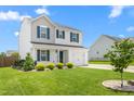 Inviting two-story home showcasing a lush green lawn, tasteful landscaping, and a cozy suburban setting at 413 Hallie Long Ln, Burlington, NC 27217