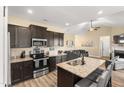 Well-lit kitchen with granite countertops, dark cabinets, and a center island with a sink at 50 N Nolan Park Dr, Selma, NC 27576