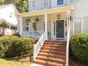 Inviting front porch adorned with hanging plants and a decorative wreath, a welcoming entryway at 513 Moultonboro Ave, Wake Forest, NC 27587
