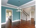 Elegant dining room with coffered ceiling, hardwood floors, and staircase at 5491 Silk Hope Gum Springs Rd, Siler City, NC 27344