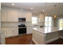 Bright kitchen features stainless steel appliances, granite countertops, and hardwood flooring at 5491 Silk Hope Gum Springs Rd, Siler City, NC 27344